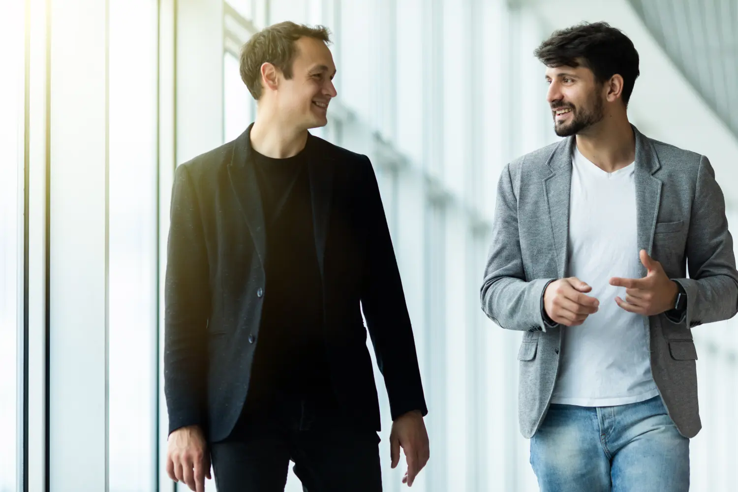 JobDirekt Rass - Regionaler Partner für direkte Personalvermittlung - Porträt zweier konzentrierter Geschäftspartner in Anzügen, die während eines Arbeitstreffens gehen und sich unterhalten.
